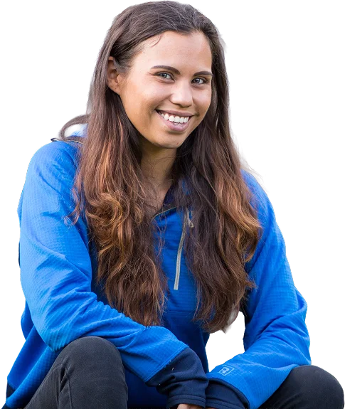GettyImages-847039762 copy 1 Woman with long brown hair wearing a blue outdoor jacket, smiling while seated
